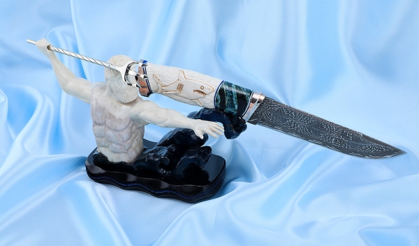 The author's composition Poseidon Damascus end, mokume-gane, blue mammoth tooth, carved walrus tusk on a stand