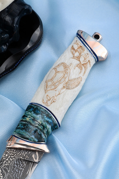 The author's composition Poseidon Damascus end, mokume-gane, blue mammoth tooth, carved walrus tusk on a stand